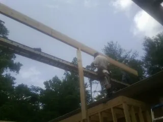 Carpenter setting a ridge beam over a new addition frame — Ice Dam Removal by Roofing Brothers in East Helena
