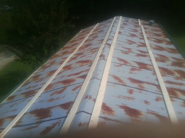 Rusted metal roof panels with new wood purlins before replacement — Storm Damage Roof Repair in East Helena by Roofing Brothers