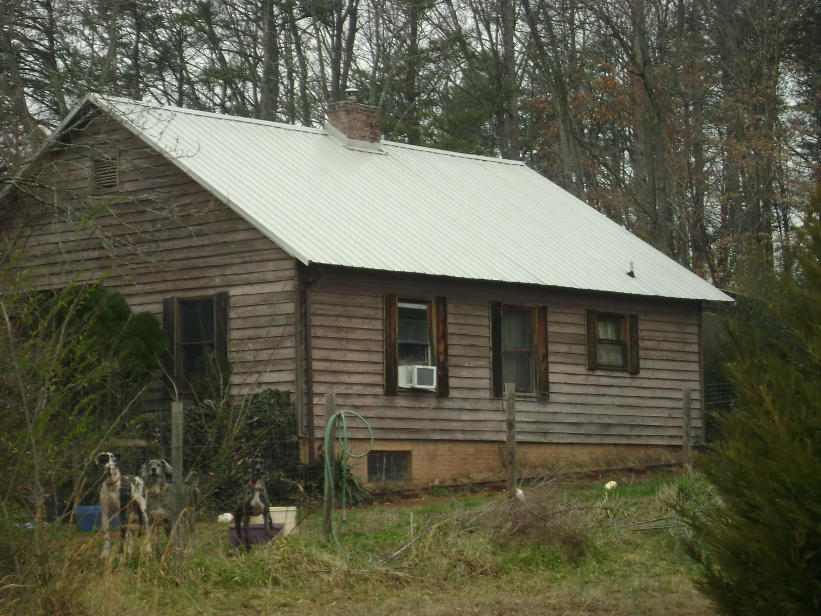 White metal roof on an old wood sided farmhouse, from a Metal Roof Installation job in East Helena